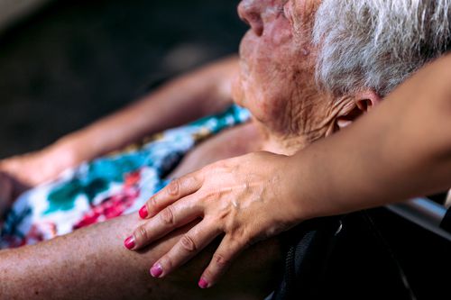 Hand of a young woman caring for an elderly woman
