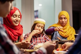 happy muslim family during iftar meal breaking ramadan fast