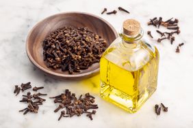 Wooden bowls with cloves and a bottle of clove oil