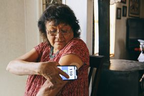 senior indigenous woman checking her blood glucose level with a smartphone application.