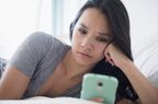 Woman looking sad and depressed using her phone
