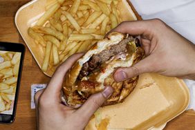 Person eating fast food hamburger