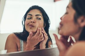Woman looking at a pimple