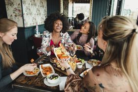 A group of women have fun while eating a meal at a restaurant 