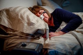 middle aged woman sleeping with cpap machine for sleep apnea