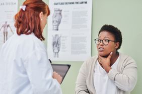 Shot of a doctor examining a womanâs throat during a consultation