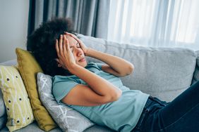 Woman not feeling well lying on her couch
