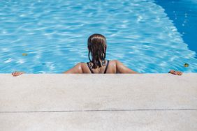 Middle-aged woman with her back turned inside a swimming pool