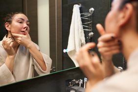 woman massaging face in mirror