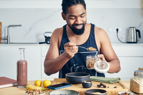 A man smiles as he prepares a healthy breakfast