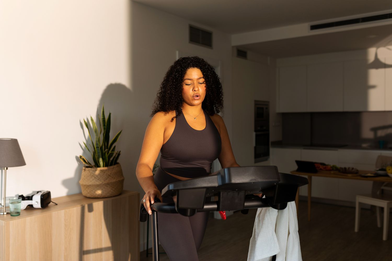 woman exercising in living room on treadmill