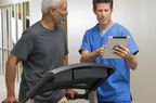 older man walking in treadmill with doctor supervision