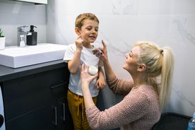 parent applying impetigo cream on child