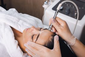 A woman receives microdermabrasion treatment. 