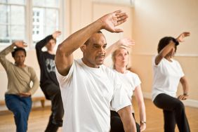 A group of people practicing Tai Chi movements in a studio