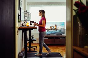 woman working at desk, walking on treadmill